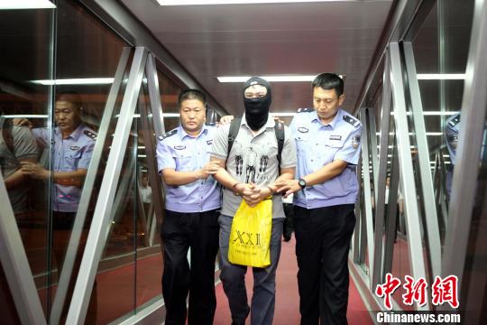图为廊坊警方将犯罪嫌疑人押解出机场。 陈丽瑢 摄
