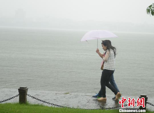 受台风“灿鸿”影响，浙江杭州西湖景区时晴时雨，游客淡定散步。 李晨韵 摄