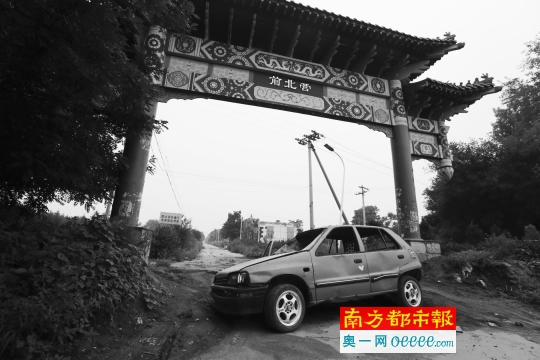 通州潞城镇前北营村到处堆积着拆迁后遗留的废料，村口的道路中间横着一辆废弃的小轿车。C FP图片